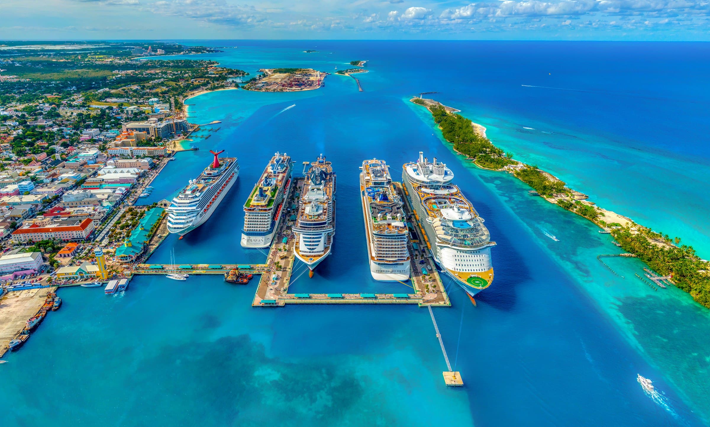 Aerial view of cruise ships docked between turquoise Bahamian waters